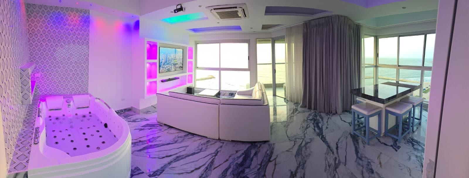 Sala con jacuzzi e iluminación LED, con el comedor junto a la ventana.
