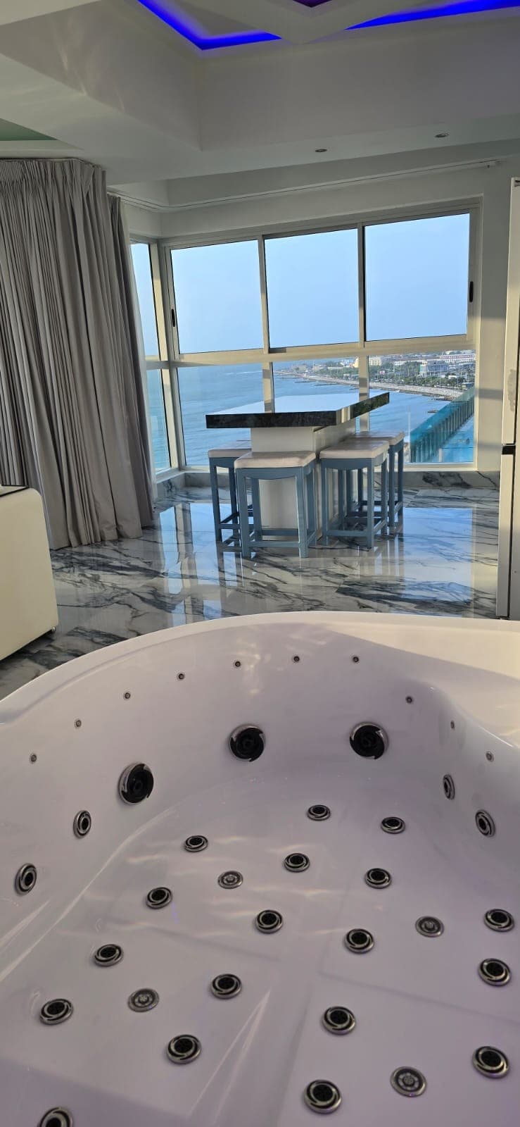 Jacuzzi de la sala visto de cerca, con el comedor y el mar al fondo.