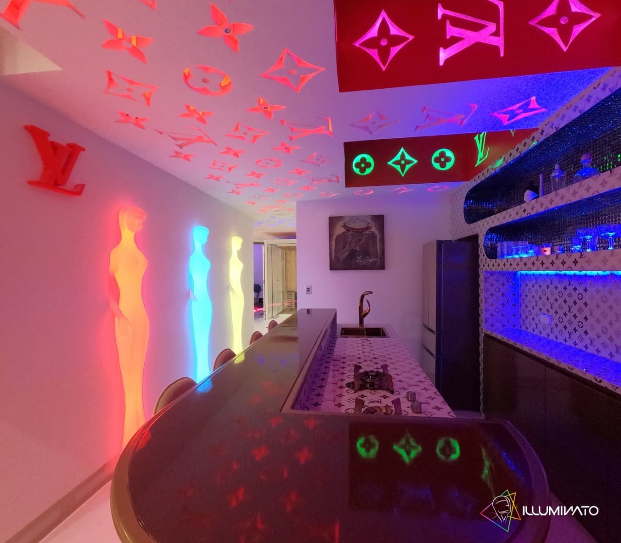 Zona social con barra, iluminación LED de colores y cielorraso decorado.