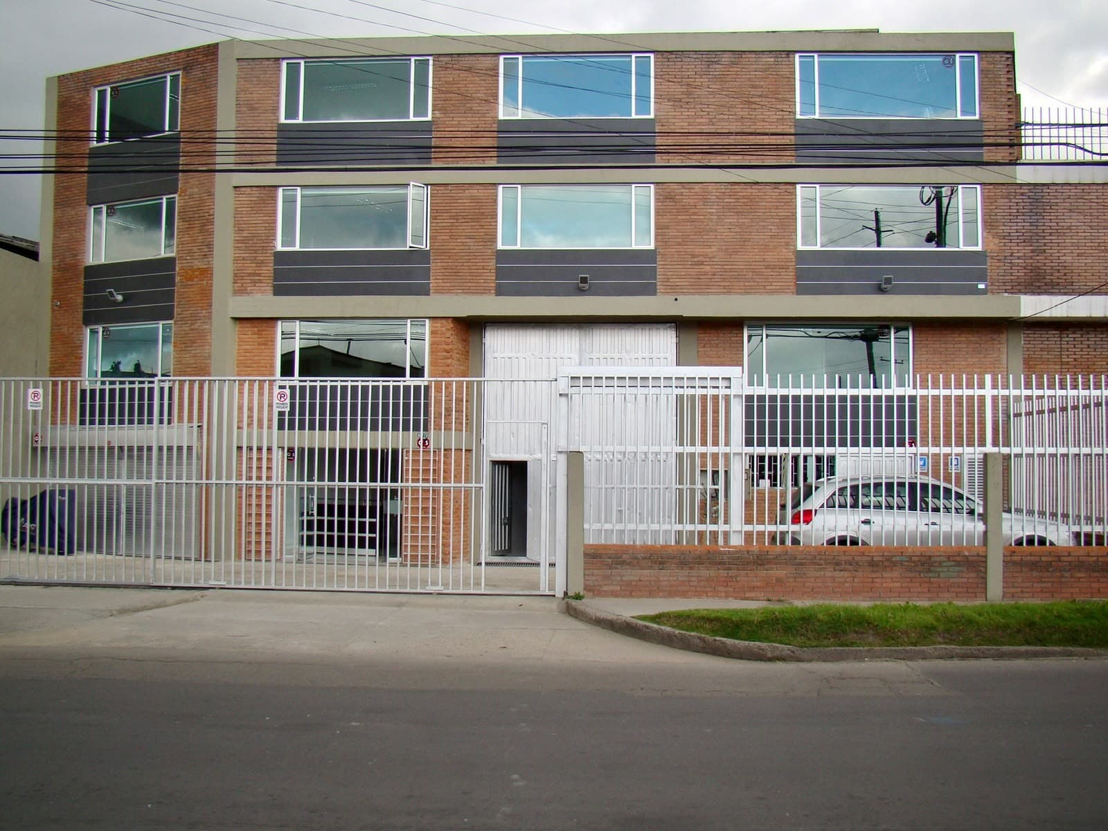 Fachada en ladrillo de la planta industrial, vista desde la calle.