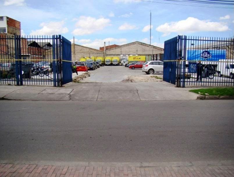 Entrada del lote con portón en reja azul y patio en concreto.