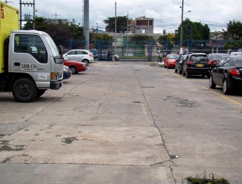 Patio en concreto del lote, con vehículos parqueados.