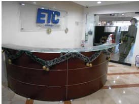 Recepción de la oficina, con mesón curvo en madera.