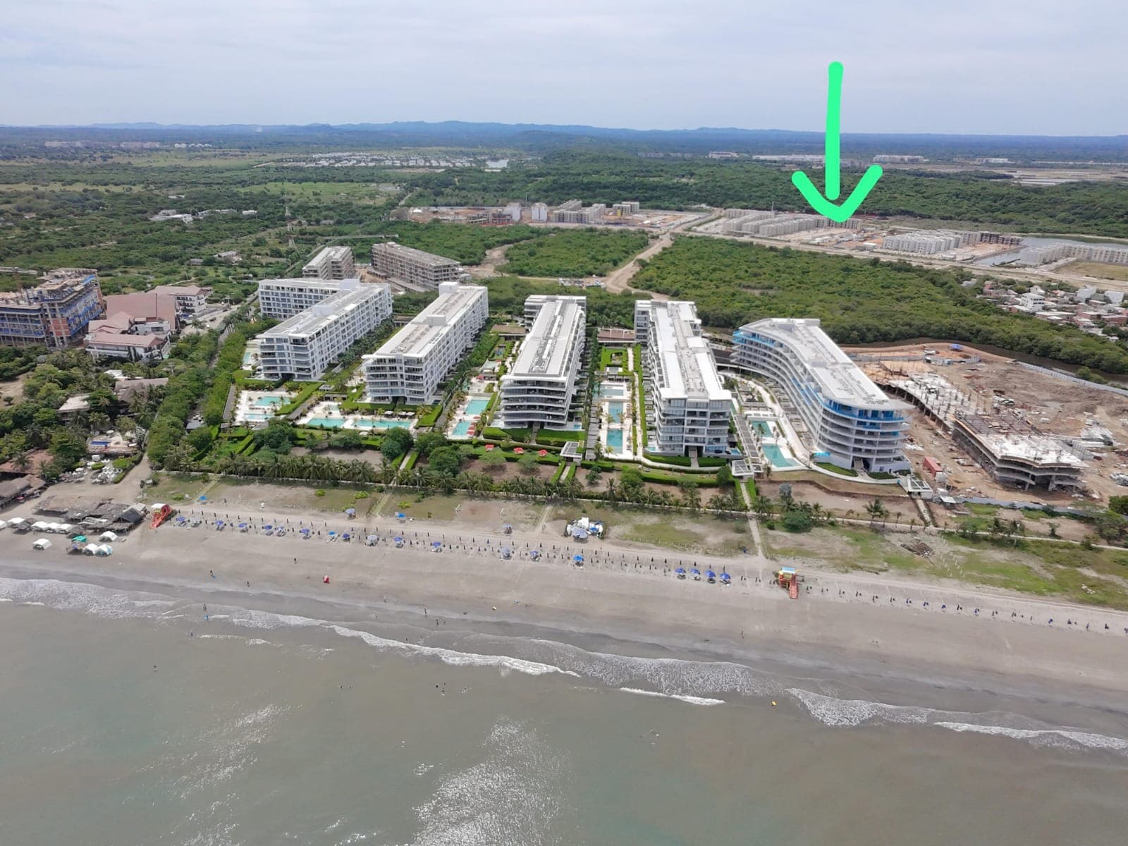 Vista aérea del conjunto frente a la playa, con una flecha que señala la torre.