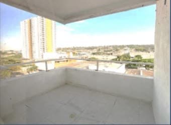 Balcón vacío del apartamento, con vista abierta a la ciudad.