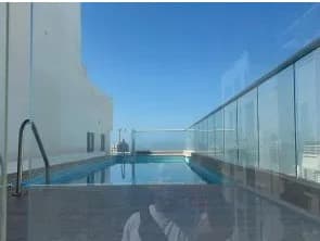 Piscina del edificio en la terraza, con baranda en vidrio.