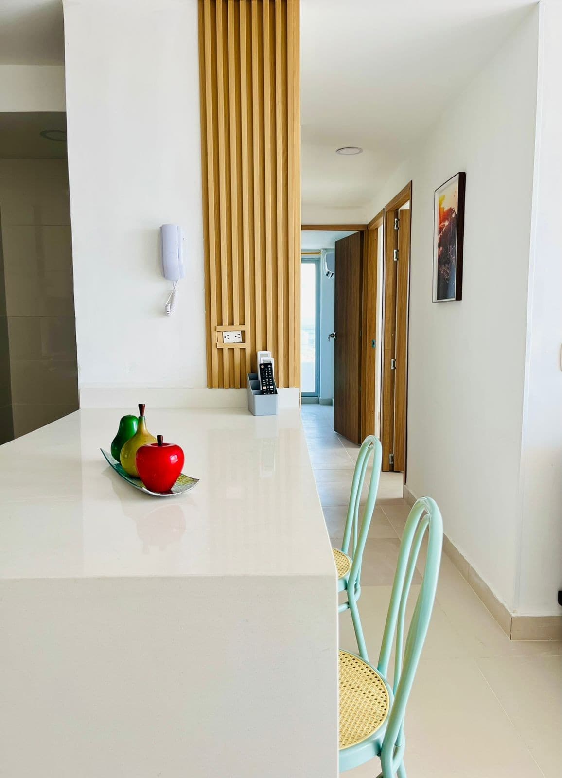 Barra de la cocina con dos butacas, junto al pasillo del apartamento.